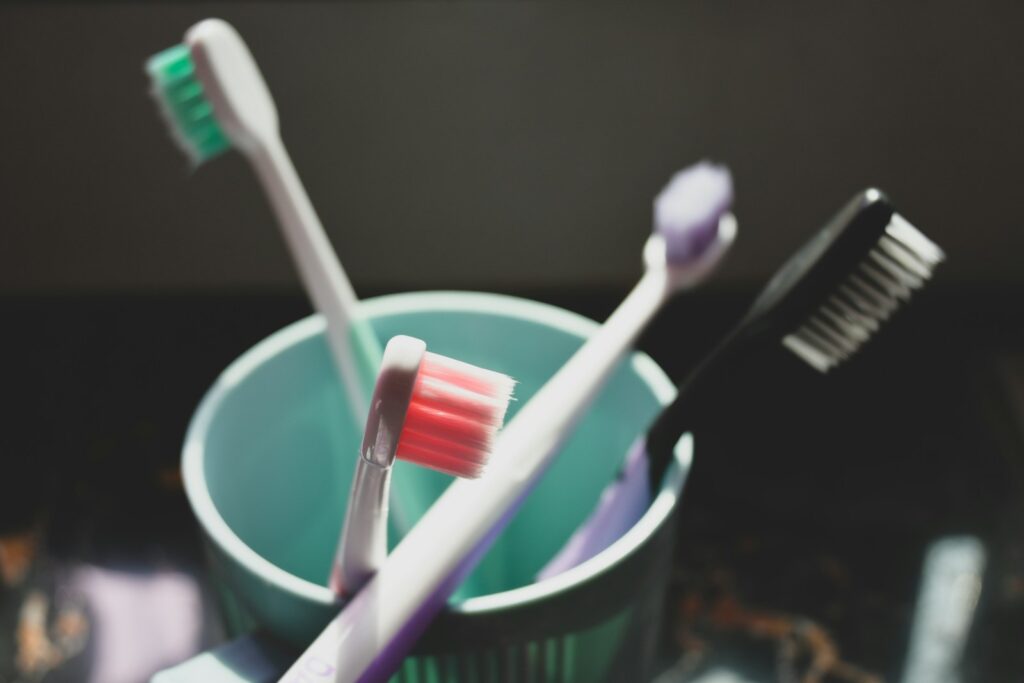 two toothbrushes in a cup with toothpaste