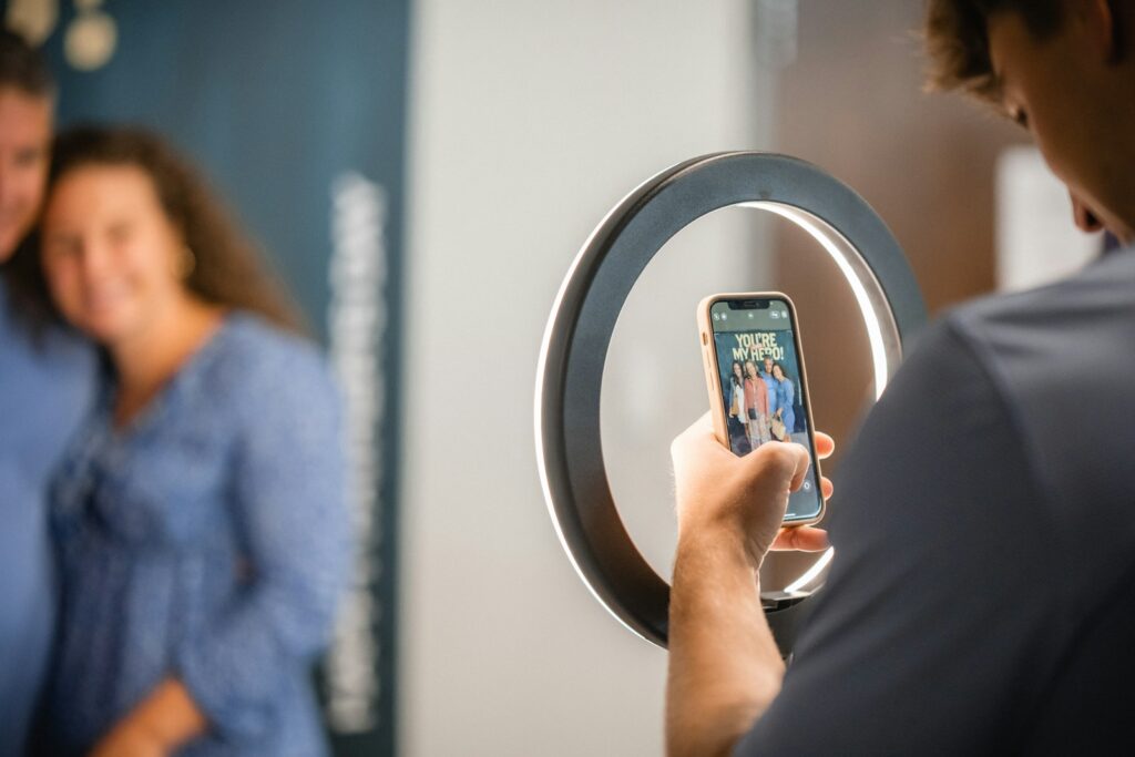 a man taking a picture of a woman using a cell phone