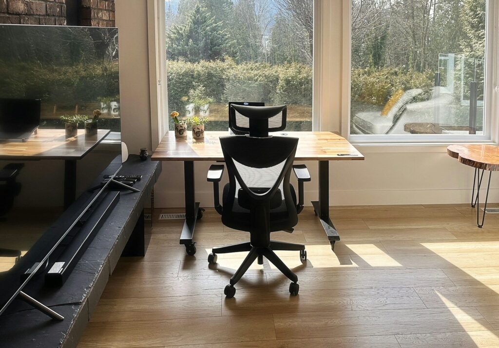 a chair sitting in front of a window next to a desk
