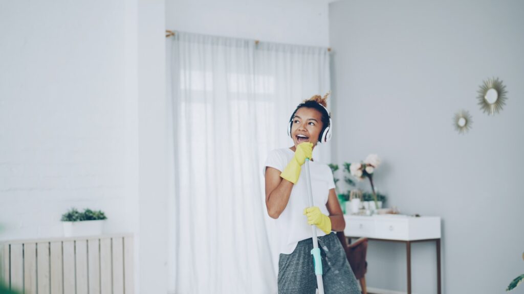 Woman wearing gloves singing while listening to music.