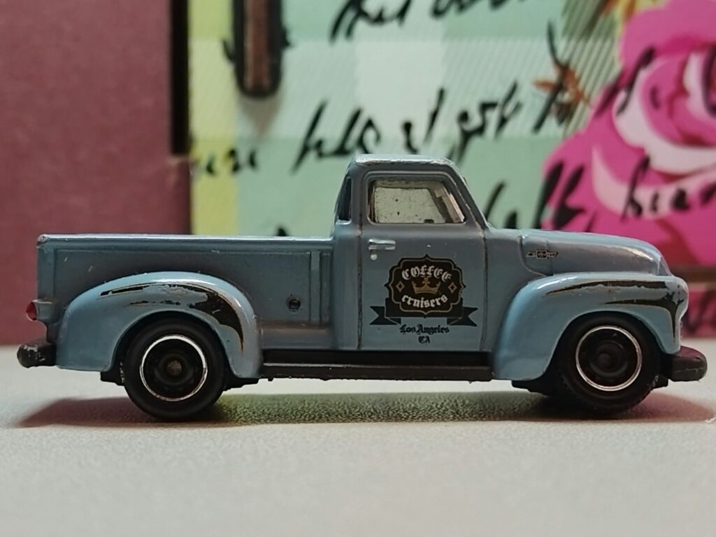 A vintage blue toy truck is shown in profile.