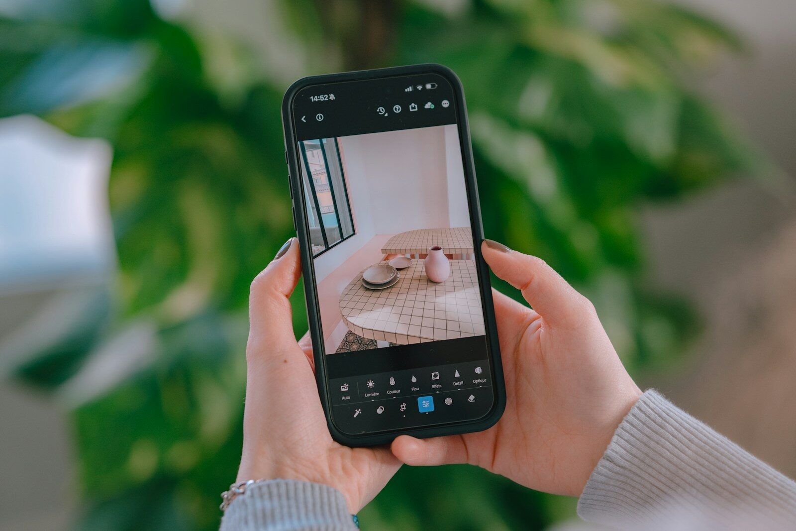 Hands holding smartphone capturing a table setting