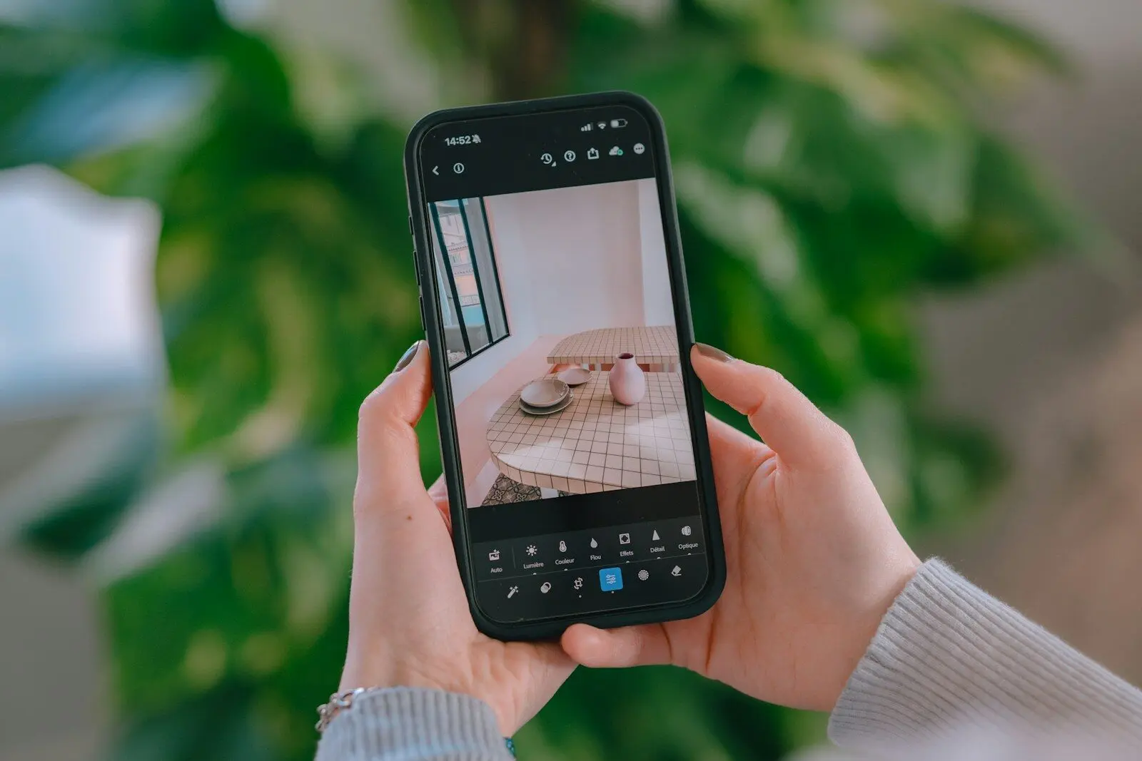 Hands holding smartphone capturing a table setting