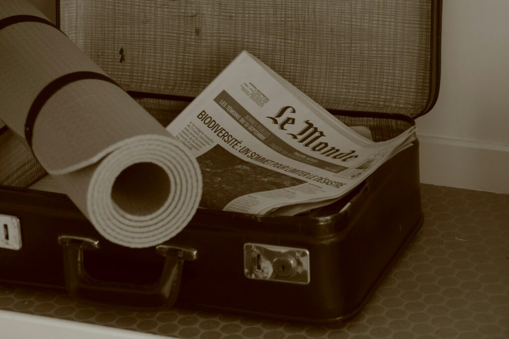 a piece of luggage with a newspaper and a roll of toilet paper