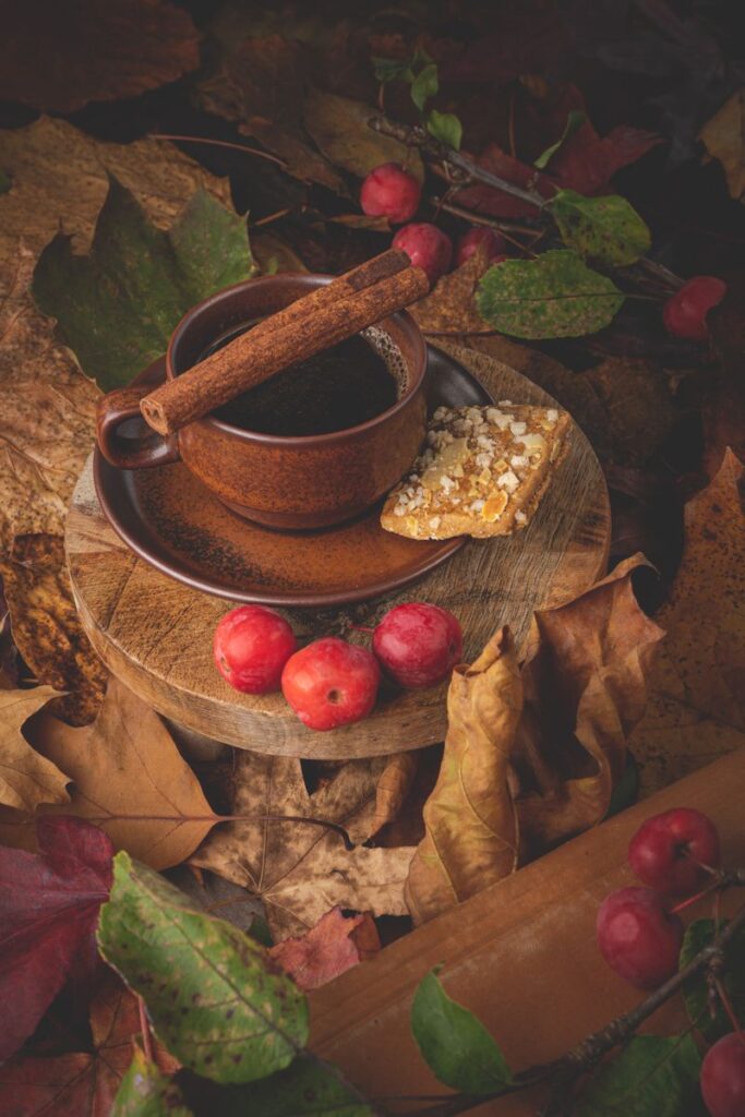 Warm autumn tea setup with rustic vibe, showcasing cinnamon and red apples.