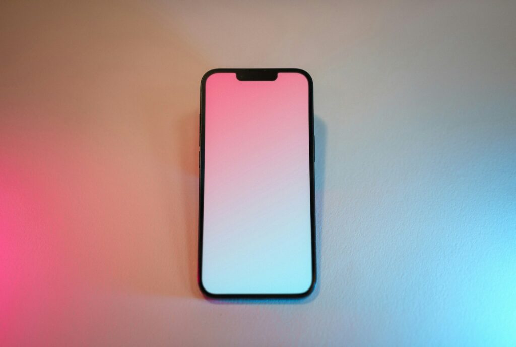 A pink and white cell phone sitting on top of a table
