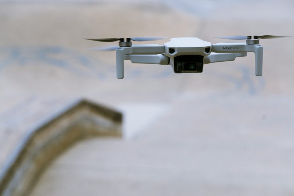 white and blue drone in mid air