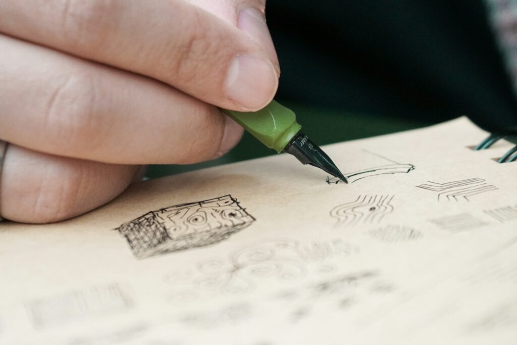 A person writing on a piece of paper with a green pen