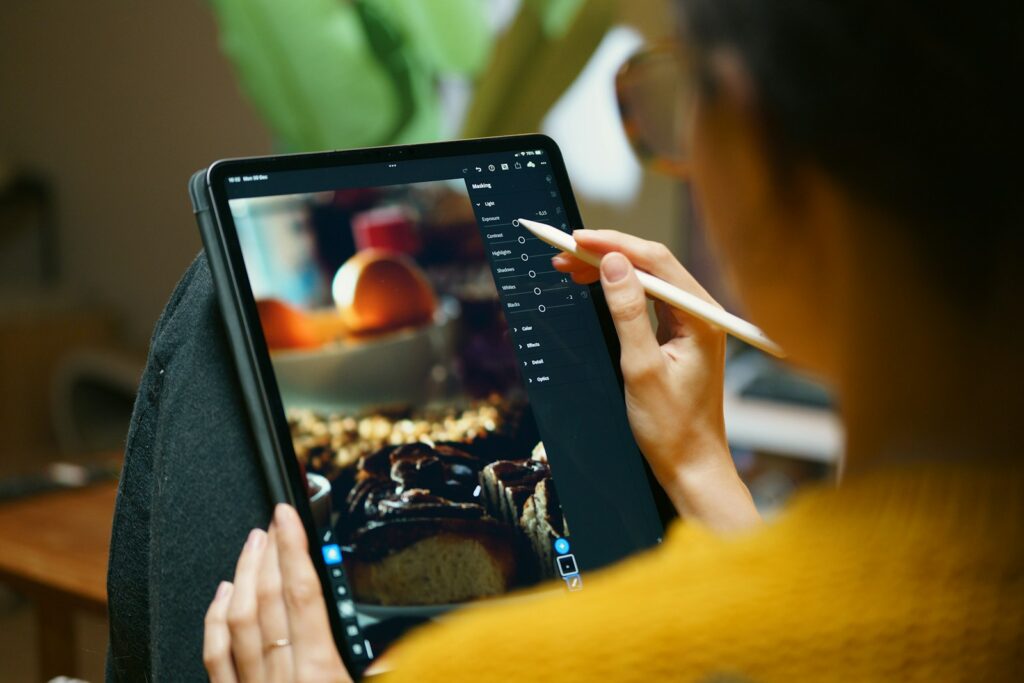 A woman is drawing on a tablet with a pencil